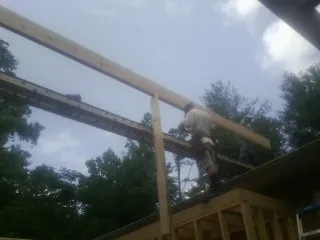 Carpenter setting a ridge beam over a new addition frame — Ice Dam Removal by Roofing Brothers in Ijamsville