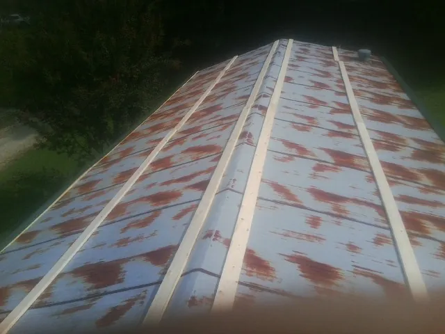 Rusted metal roof panels with new wood purlins before replacement — Storm Damage Roof Repair in Ijamsville by Roofing Brothers
