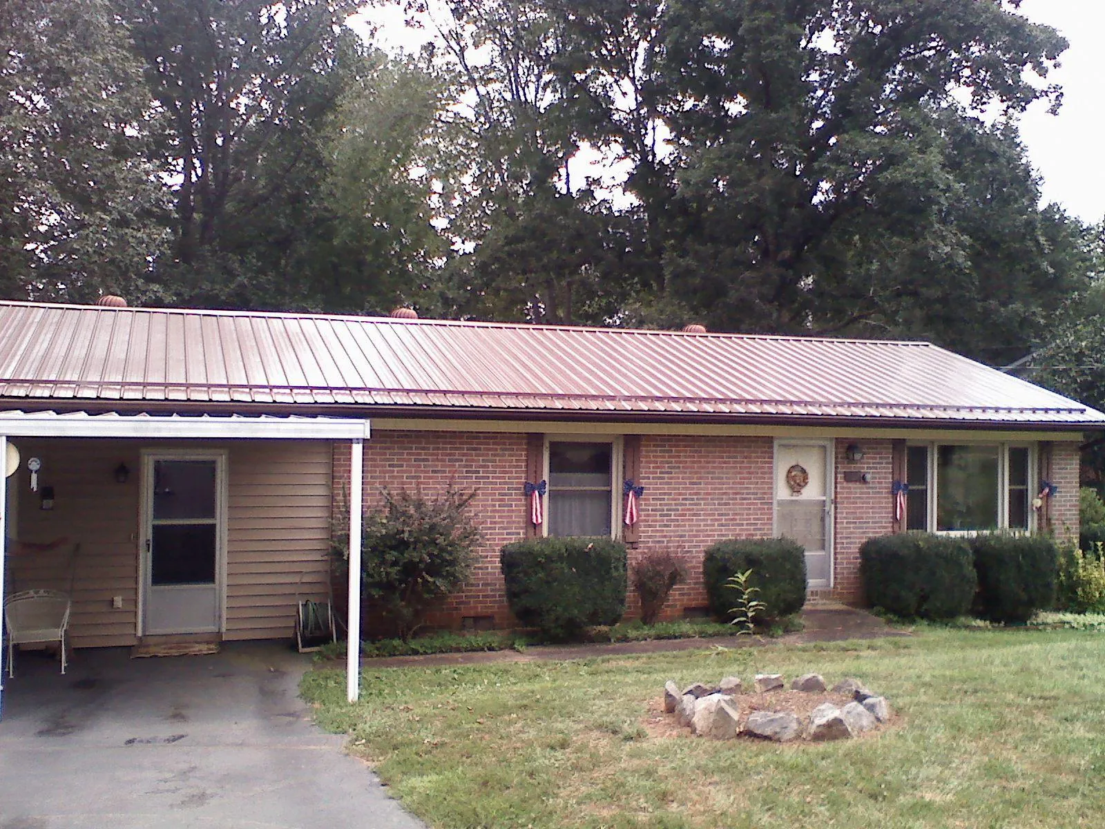 Bronze metal roof and carport on a brick ranch home — Roof Repair work by our crew in Ijamsville